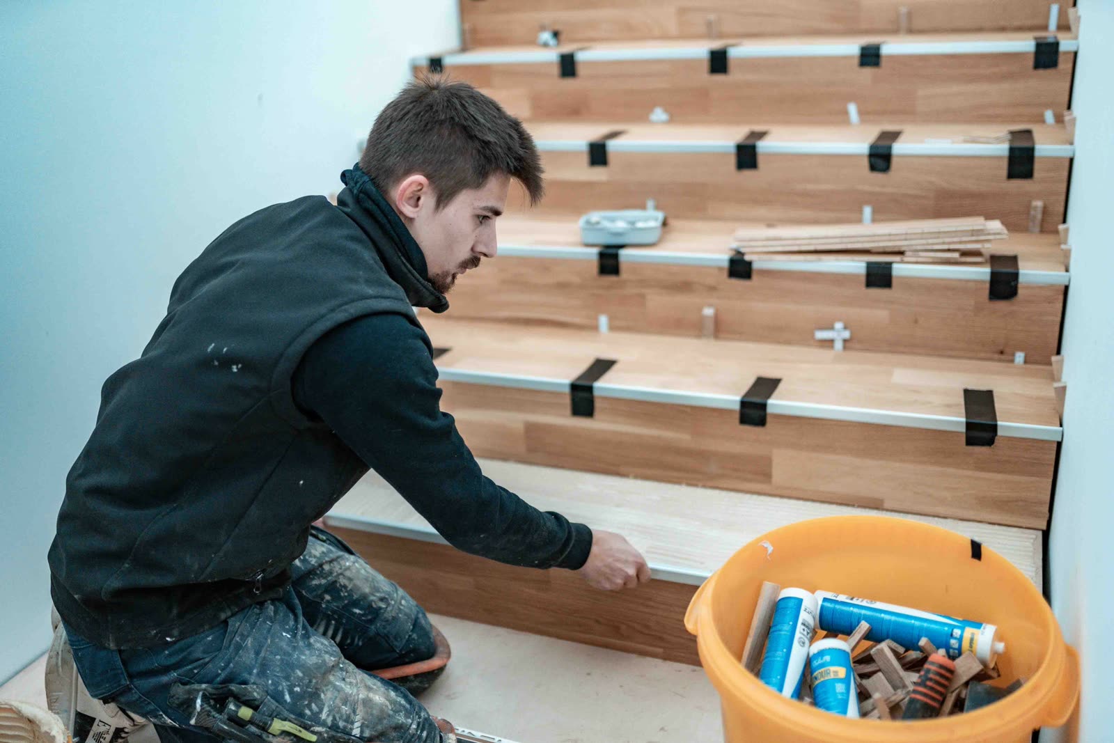 Handwerker verlegt Holzstufen bei einem Innenausbauprojekt