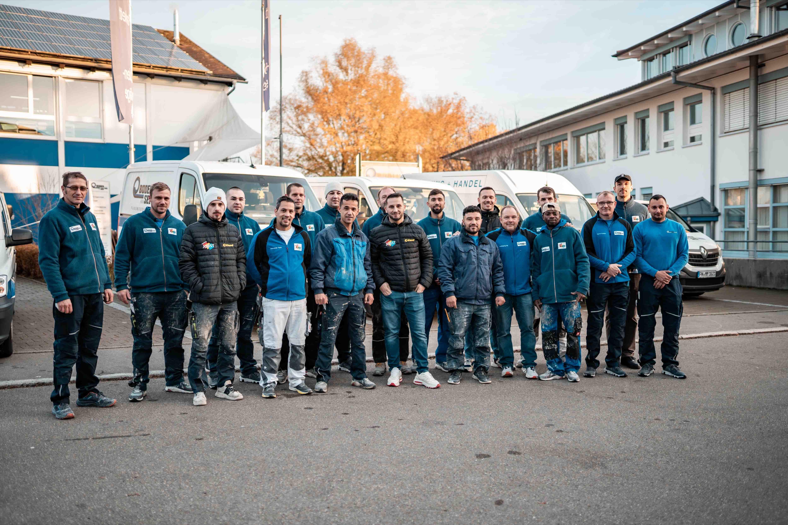 Teammitglieder vor den Fahrzeugen eines Unternehmens der MOMA Gruppe